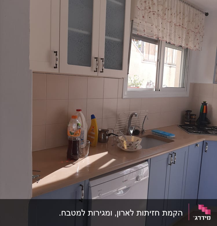 מטבח עם ארונות עץ ודלתות זכוכית
